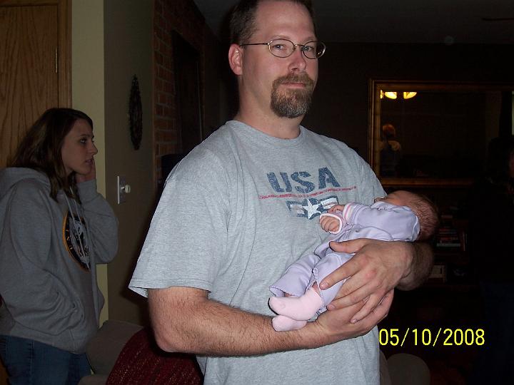 100_3594.JPG - New uncle Don holding Macie while Gina checks her phone in the background.